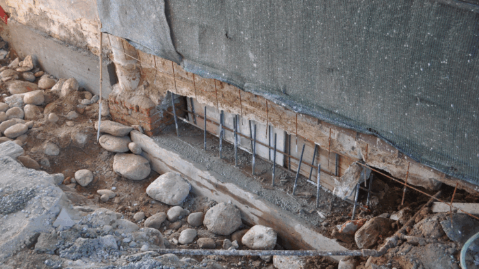 Underpinning | Underpinning work on an exterior wall with exposed support beams