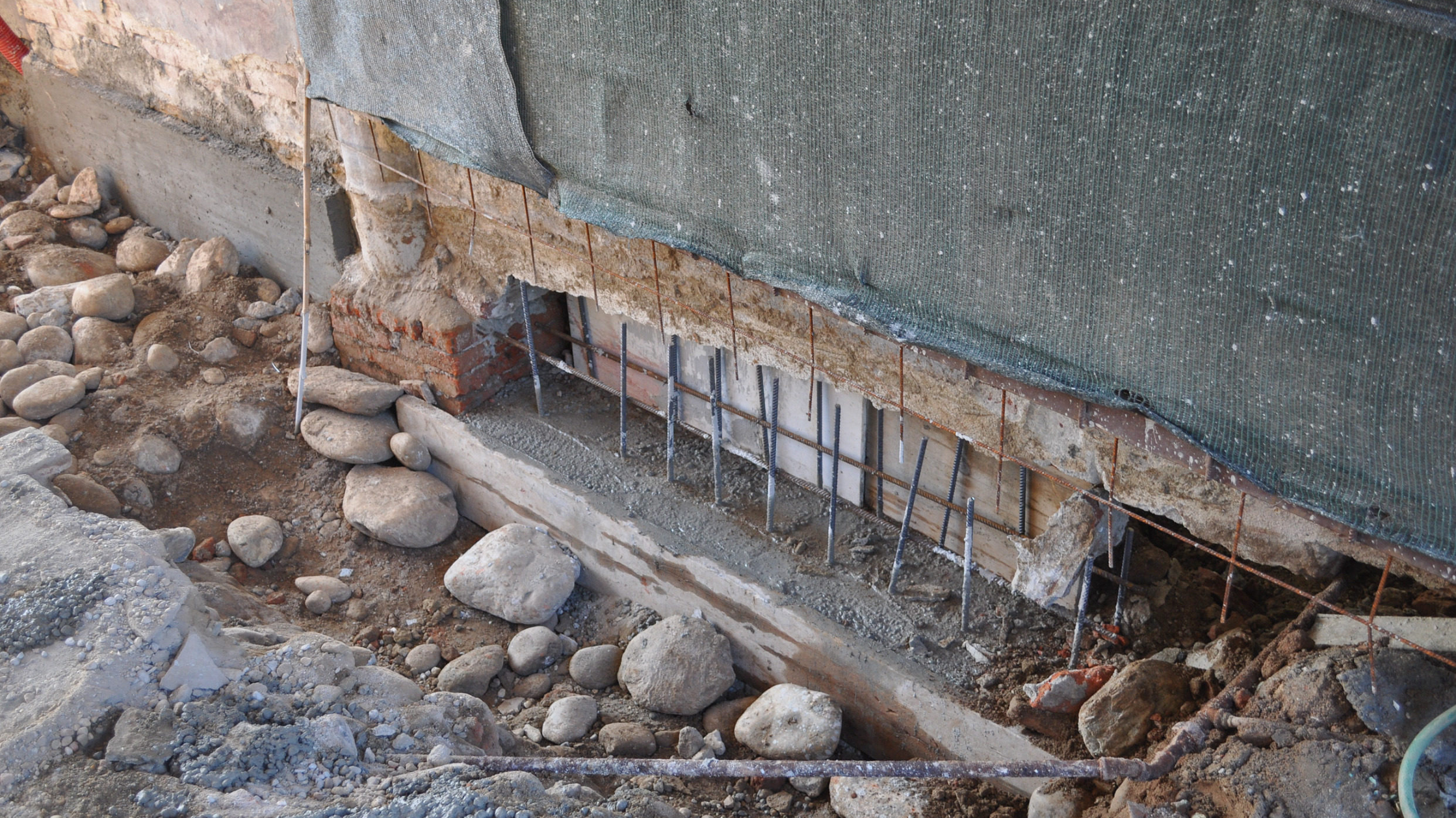 Underpinning | Underpinning work on an exterior wall with exposed support beams